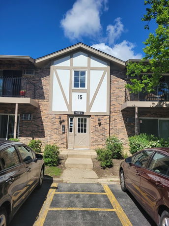 Front view of a two-story brick building with balconies and a central entrance.