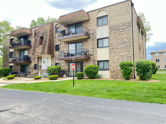 Front view of a multi-story apartment building with balconies.