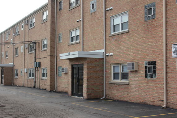 Front view of a multi-story brick apartment building.