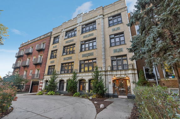 Front view of a multi-story brick building with decorative elements.