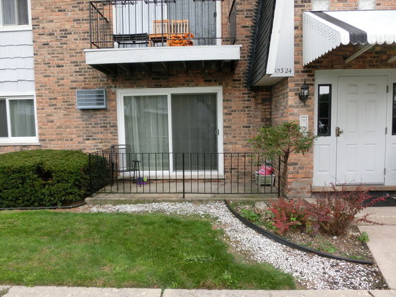 Front view of a building with a balcony and entrance door.