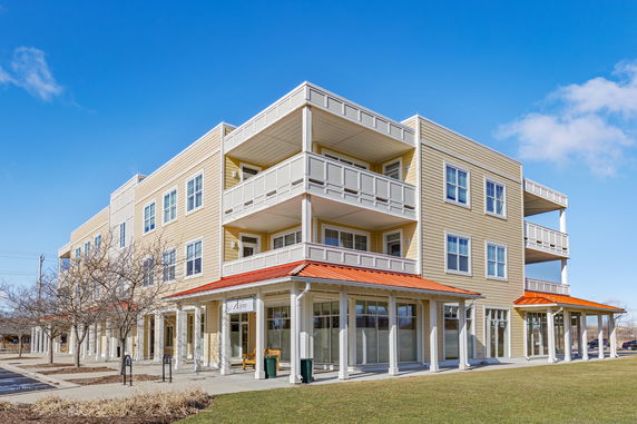 Front view of a modern three-story building with balconies.