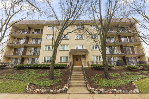 Front view of a multi-story apartment building with balconies.