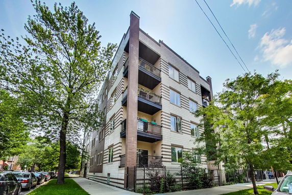Front view of a multi-story residential building with balconies.