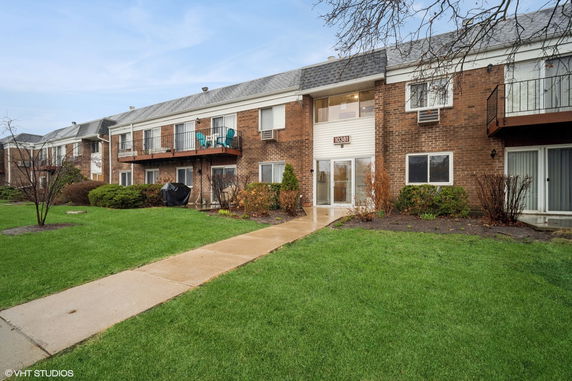 Front view of a two-story brick apartment building with balconies.