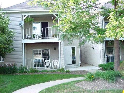 Front view of a two-story building with balconies and a white door.