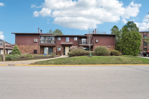Front view of a two-story building with brick and wood siding.