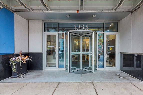 Front view of a building entrance with a revolving door and glass windows.