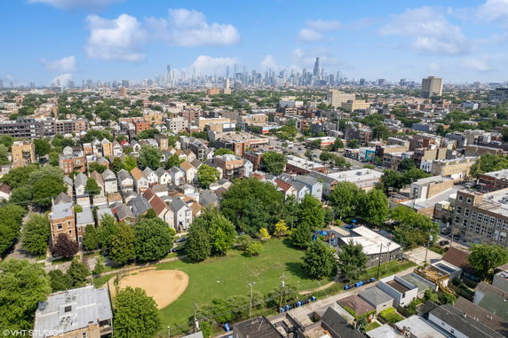 Panoramic view of a cityscape with residential areas and skyscrapers in the background.