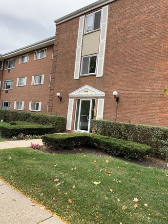 Front view of a multi-story brick apartment building.