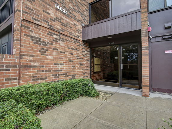 Front view of a brick building entrance with glass doors.