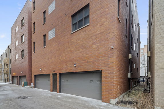 Front view of a multi-story brick building with garage doors.
