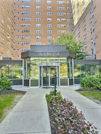 Front view of a multi-story residential building with a glass entrance.
