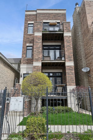 Front view of a multi-story brick building with balconies.