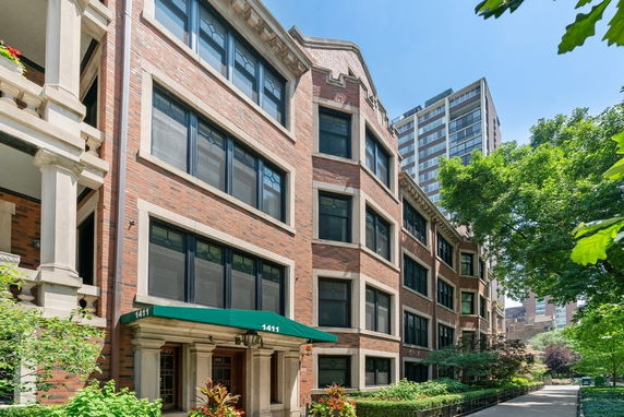 Front view of a multi-story brick apartment building with large windows.