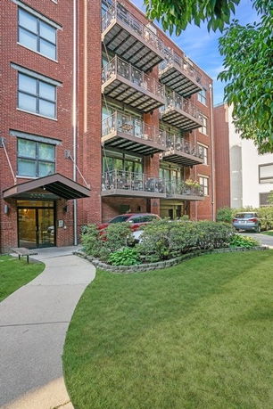 Front view of a multi-story brick building with balconies.