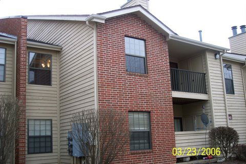 Front view of a multi-story apartment building with a brick and siding exterior.