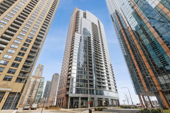 Front view of a modern high-rise building with glass and brick facade.