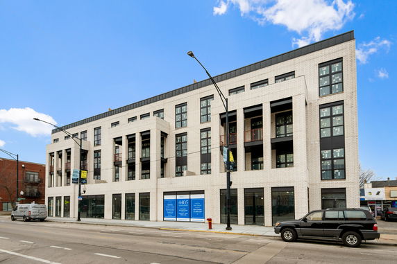 Front view of a multi-story commercial building with large windows and a modern design.