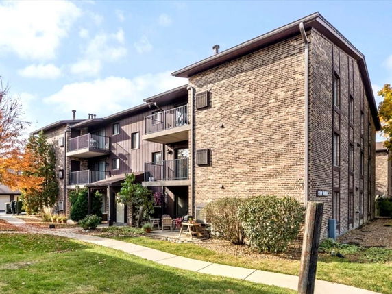 Front view of a multi-story brick building with balconies.