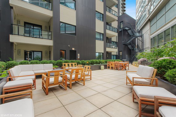 Rooftop seating area with outdoor furniture and view of adjacent buildings.