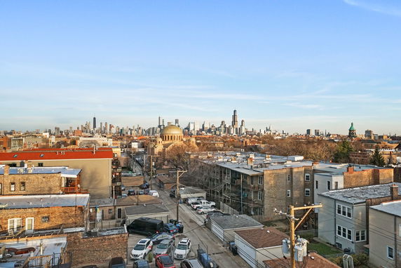 Panoramic view of an urban area with various buildings and a city skyline in the distance.