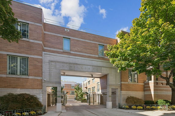 Front view of a multi-story brick building with an arched entrance.