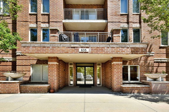 Front view of a brick apartment building with balconies.