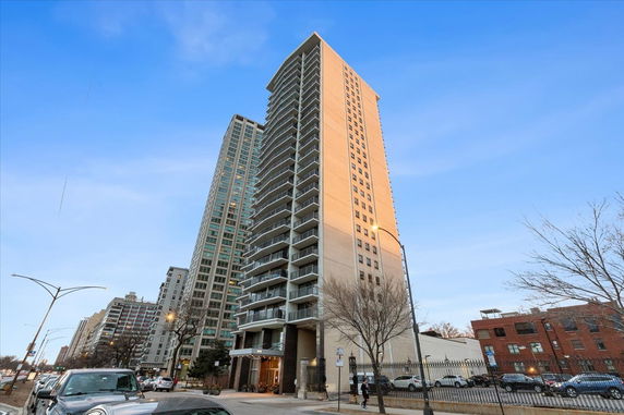 Front view of a high-rise residential building with multiple balconies.