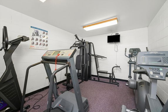Indoor gym with exercise machines, including treadmills and weight equipment.