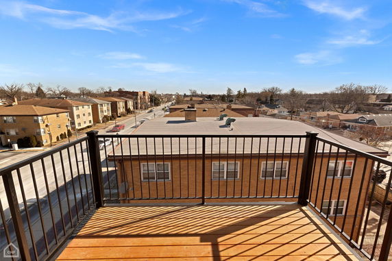 Panoramic view of rooftops and residential street from a balcony.