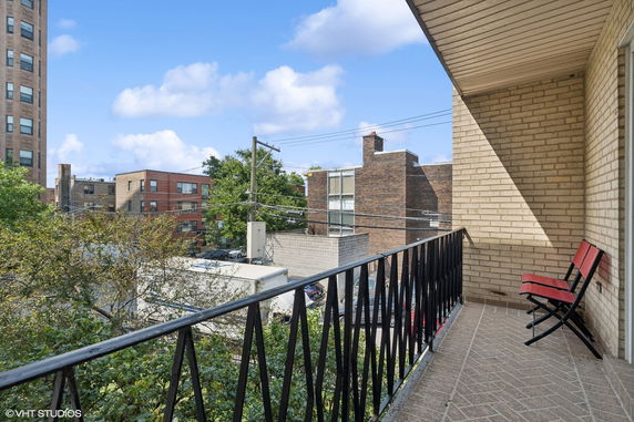 Balcony view overlooking surrounding buildings and trees.