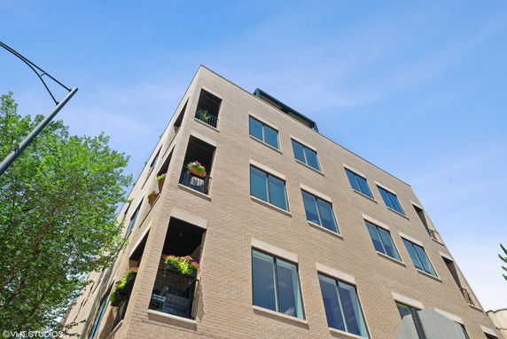 Front view of a multi-story brick building with balconies.