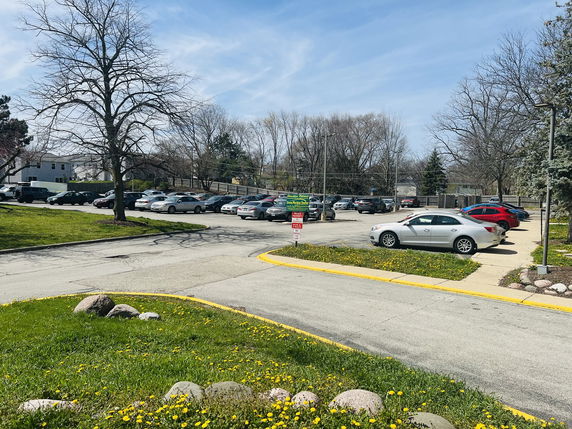 Outdoor parking area with several cars parked.