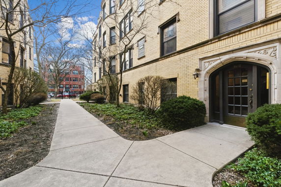 Front view of a building with a pathway leading to an arched entrance.