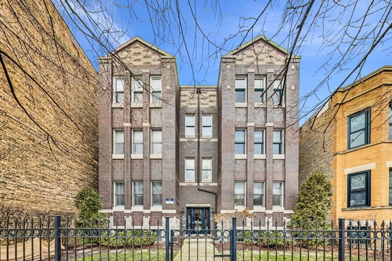 Front view of a multi-story brick building with symmetrical design.