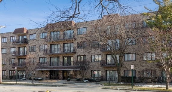 Front view of a multi-story apartment building with a brick facade.