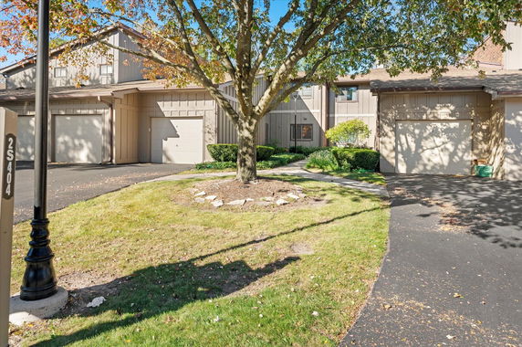 Front view of a two-story house with a garage and a driveway.