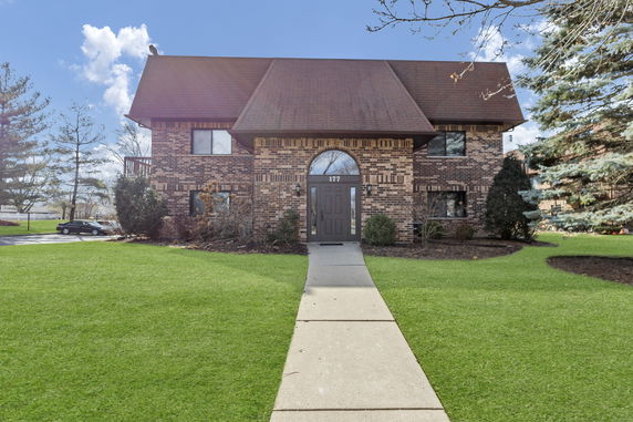 Front view of a two-story brick house with a gabled roof.