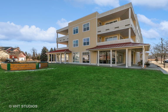 Front view of a multi-story residential building with balconies and large windows.