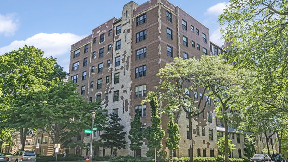 Front view of a multi-story brick building with ornate stone detailing.