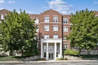 Front view of a multi-story brick building with trees on either side.