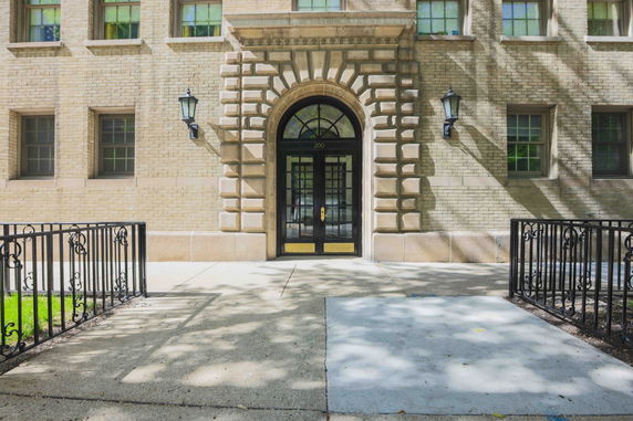 Front view of a building with an arched entrance and decorative brickwork.