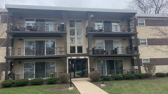 Front view of a multi-story apartment building with balconies.