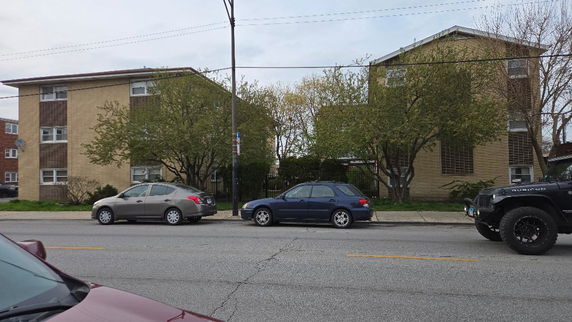 Front view of a three-story apartment building with a flat roof.