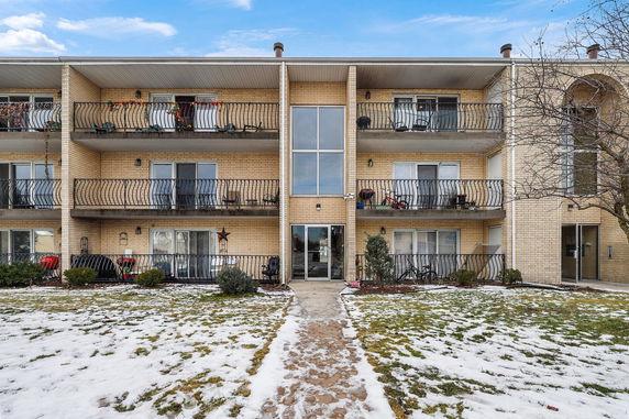 Front view of a three-story apartment building with balconies.