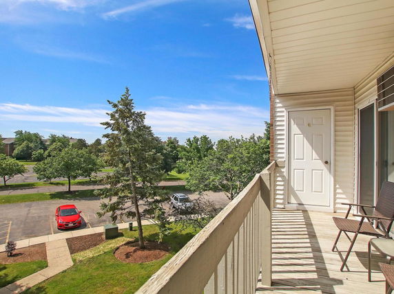 View of surrounding area and trees from a building balcony.