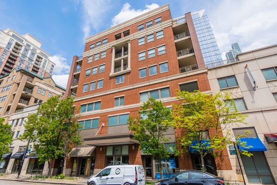 Front view of a multi-story brick building with large windows and balconies.