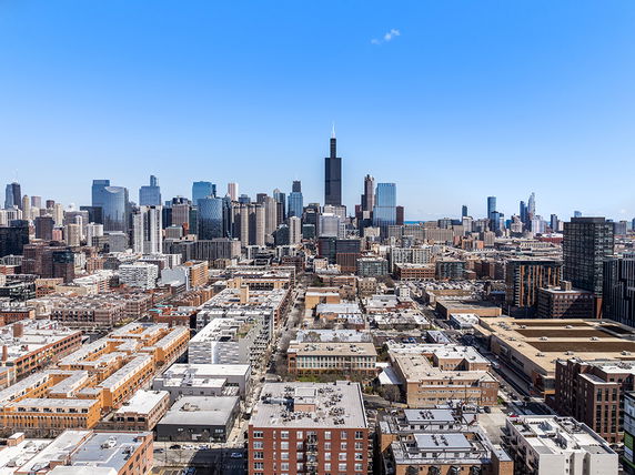 Panoramic view of a city skyline with a mix of high-rise and low-rise buildings.