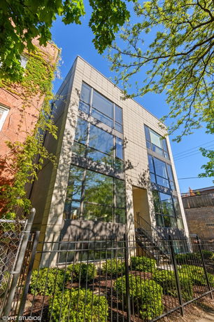 Front view of a modern multi-story building with large windows.